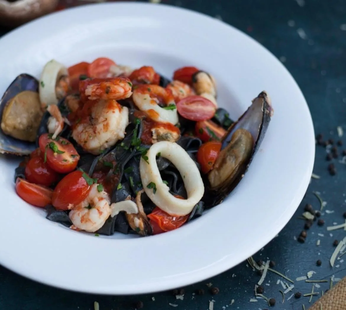 Tagliatelle negros con frutos de mar y salsa de tomate